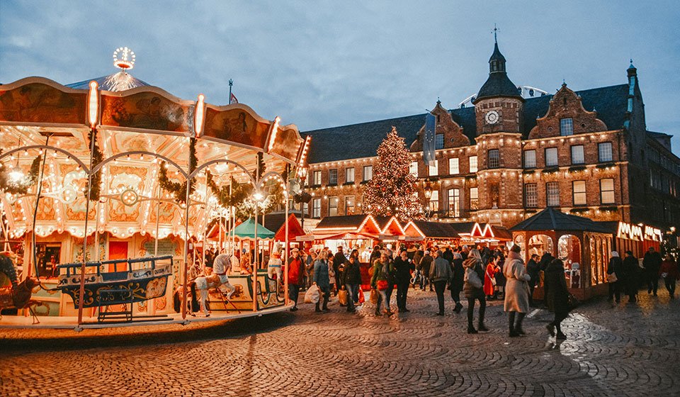 Weihnachtsmarkt in der Düsseldorfer Innenstadt vor dem Rathaus: festliche Stände mit Geschenken, Lichtern und Glühwein.