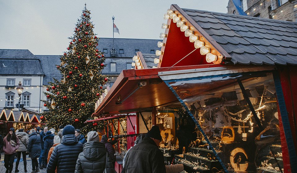 Weihnachtsmarkt in der Düsseldorfer Innenstadt: festliche Hütten mit Handwerkskunst, besinnliche Atmosphäre, großer geschmückter Weihnachtsbaum 