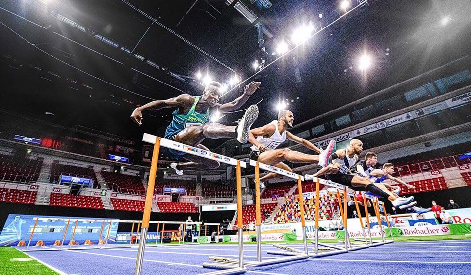 Sportler:innen springen über die Hürden beim Hürdenlauf
